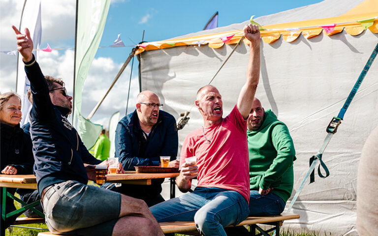 Mannen zingen en juichen bij feesttent